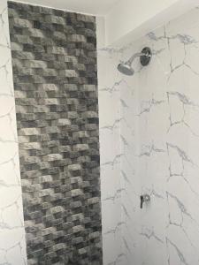 La salle de bains est pourvue d'une douche et d'un mur en briques. dans l'établissement Apus Paradise House Valle Sagrado, à Urubamba