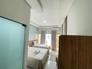 a hotel room with two beds and a television at Hotel Pé de Serra Piranhas in Piranhas