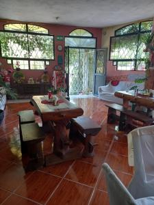 a living room with wooden tables and chairs at Casa Huespedes El Molino in Tababela