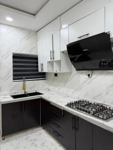 a kitchen with white cabinets and a stove top oven at MOTF Home in Okunola
