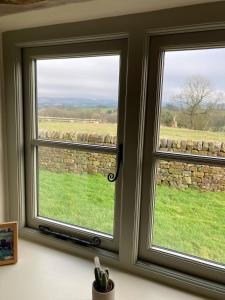 a window with a view of a field at Peace & Tranquillity - Breathe Nature & Star Gaze in Eaton +4 photos