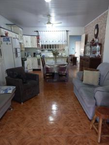 ein Wohnzimmer mit 2 Sofas und einer Küche in der Unterkunft Casa da Marina in Três Coroas