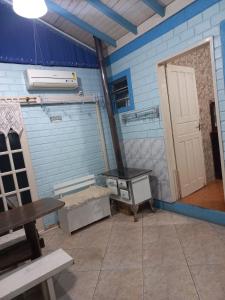 Zimmer mit einer Tür, einem Tisch und einer Bank in der Unterkunft Casa da Marina in Três Coroas + 29 Fotos