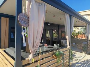 a screened in porch with a table and umbrella at Villa Isabell - Camp Limoni 12 in Sukošan