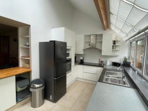a kitchen with a black refrigerator and a sink at Gite grand jardin nature Ardenne Luxembourg in Nassogne +31 photos