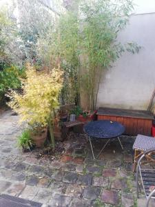 une terrasse avec une table, des bancs et des plantes dans l'établissement Diderot, à Montreuil
