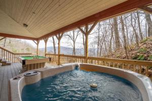 a hot tub on a deck with a pool table at Dream Weaver in De Hart Mill