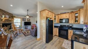 a kitchen with wooden cabinets and a black refrigerator at The Cottage on Douglas Lake Cove in Dandridge