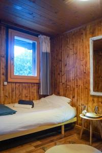 a bedroom with a bed in a wooden wall at Charmant Appartement Alpin in Oberems