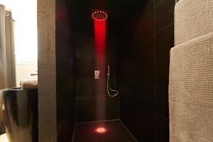 a shower with a red light in a bathroom at Crystal Love Appart in Pornichet +18 photos
