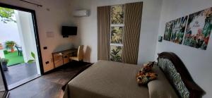a bedroom with a bed and a desk and a television at INN My Place in Selargius