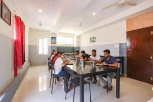 un grupo de personas sentadas en una mesa en un restaurante en FabExpress Starhood - Nr Lanco Hills, Manikonda, en Gundipet