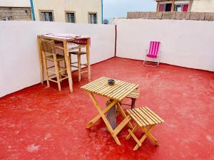a patio with two chairs and a table and stool at fulki house in Taghazout