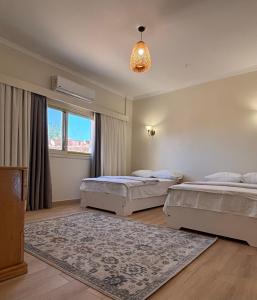 a bedroom with two beds and a chandelier at Golden Sun House II in Abu Simbel