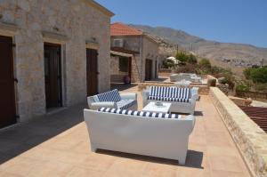a patio with white couches on top of a building at Villa Blu Majestic beach villa in Halki