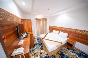 a hotel room with a bed and a television at Saif Plus 1 Hotel by Orvana in Makkah +47 photos