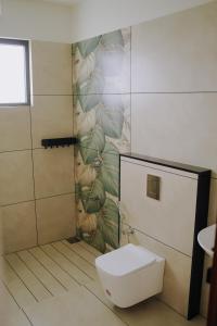 a bathroom with a toilet and a mural of plants at Camplights Stays in Tariyod +51 photos