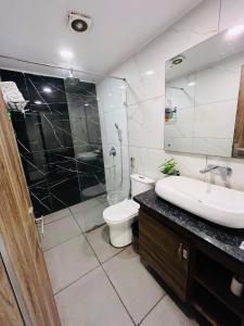 a bathroom with a sink and a toilet and a mirror at Hotel Maira in Dehradun +16 photos