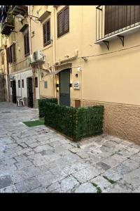 a building with a hedge in front of a building at Armonia Serenity Room Politeama in Palermo