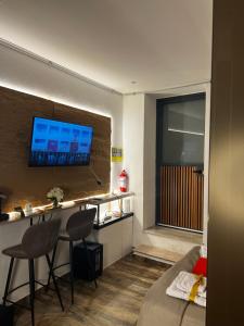 a room with a bed and a desk with a television on the wall at Armonia Serenity Room Politeama in Palermo