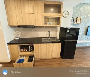 a kitchen with a sink and a black refrigerator at Chanhchua Apartment Quy Nhon in Quy Nhon