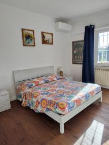 ein Schlafzimmer mit einem Bett mit einer bunten Bettdecke in der Unterkunft Chill out Home Fregene Family Group Accomodation - 15 minuti da Fiumicino - Casa Vacanza Fregene vicino al mare in Fregene