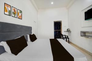 a bedroom with a white bed and a window at Hotel O BHU Formerly The Regal Inn in Kakarmatha