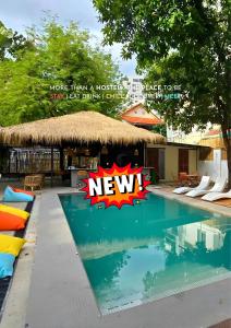 Una piscina de resort con un nuevo cartel en THE PLACE Hostel Phnom Penh, en Phnom Penh