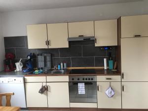 a kitchen with white cabinets and a stove top oven at Gästehaus-Eichwald in Neuenbürg