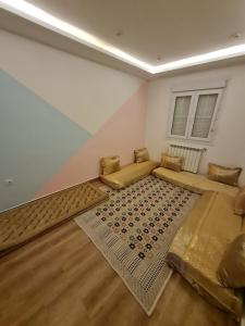 a living room with two beds and a rug at Modern luxury apartment -f4- central Sétif in Sétif