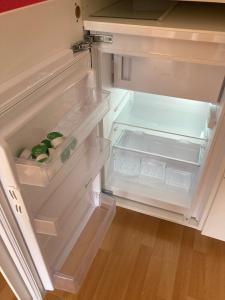 een lege koelkast met de deur open in een keuken bij RoDo - kleines ruhiges Condo an der A8 in Kirchheim unter Teck