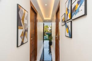 a hallway with paintings on the walls and a door at FabHotel Airport Palace - Nr Mumbai International Airport in Mumbai
