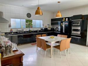 una cocina con mesa blanca y sillas. en COP30 ALTO PADRÃO Belém Brasil, en Belém