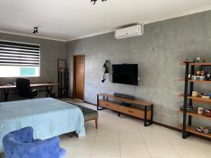 1 dormitorio con 1 cama, TV y escritorio en COP30 ALTO PADRÃO Belém Brasil, en Belém