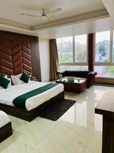 a bedroom with a large bed and a couch at Hotel Maira in Dehradun