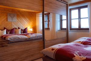 Un dormitorio con dos camas en una habitación con paredes de madera. en Arishorst Aussergasteighof, en Weerberg