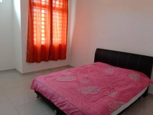 a bedroom with a bed with a pink comforter and a window at The Diana Residence Muar in Muar
