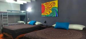 um quarto com duas camas e uma pintura na parede em Jungle Beach Hotel Manuel Antonio em Manuel Antonio
