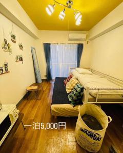 ein Schlafzimmer mit einem Bett in einem Zimmer mit Holzboden in der Unterkunft KT-HouSe Fukuoka ダブル in Sumiyoshi