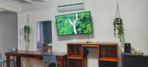um quarto com uma secretária e uma televisão na parede em Jungle Beach Hotel Manuel Antonio em Manuel Antonio