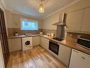 eine Küche mit Waschmaschine und Trockner in der Unterkunft Lesmar Highland Retreat in Fort William + 12 Fotos