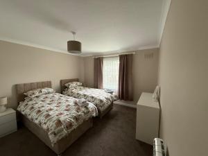 ein Schlafzimmer mit zwei Betten und einem Fenster in der Unterkunft Lesmar Highland Retreat in Fort William