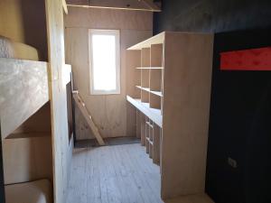 an empty room with a window and a book shelf at Refugio Cerro Castillo in Villa Cerro Castillo