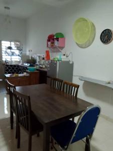 a kitchen with a wooden table and chairs at Aisy Cottage tikey in Batu Kikir