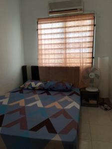 a bedroom with a bed in front of a window at Aisy Cottage tikey in Batu Kikir