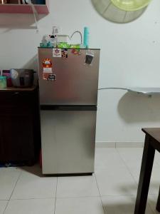 a small refrigerator in a kitchen with a counter at Aisy Cottage tikey in Batu Kikir +2 photos