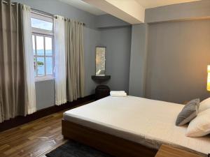 een slaapkamer met een groot bed en een raam bij Khangrila Nest Homestay in Sombāri