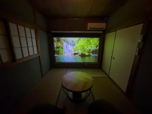 a room with a window with a view of a waterfall at Totono Amami in Karitachō