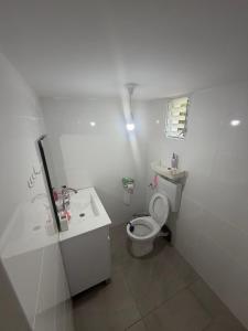 a white bathroom with a toilet and a sink at יחידת דיור חדשה עם מקלט - היחידה בגליל in Qiryat Shemona