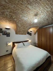 a bedroom with a large bed and a brick wall at Ca' D'Rosina in Narzole +29 photos